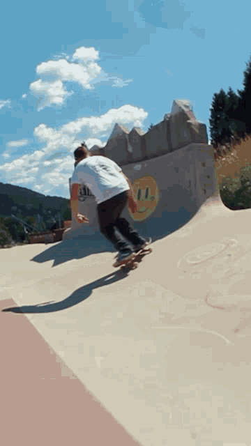 a skateboarder is doing a trick on a ramp with a smiley face on it