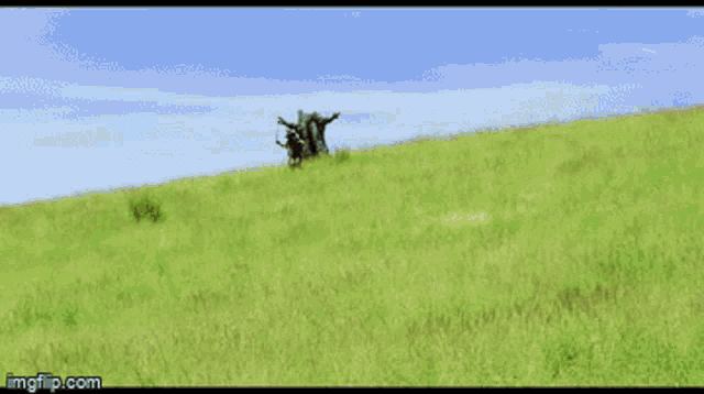 a man holding a sword is running through a grassy field ..