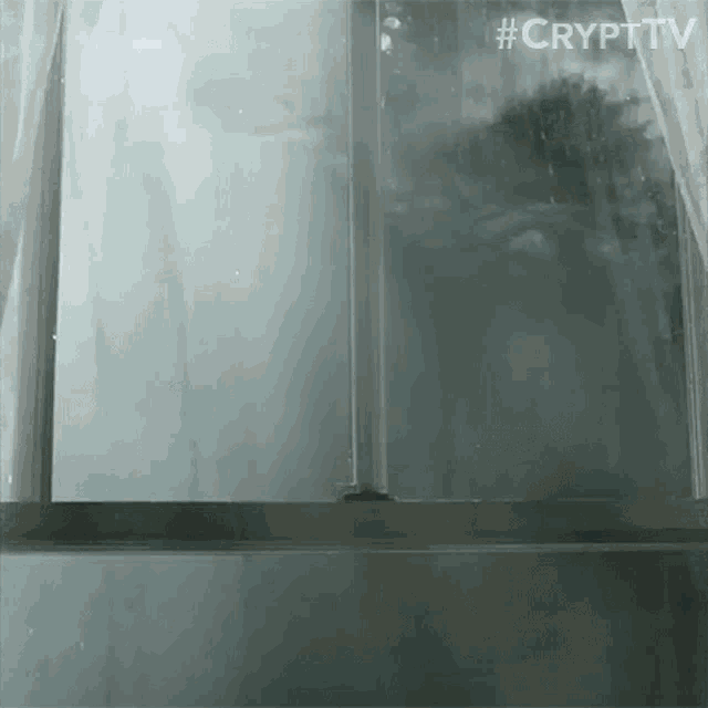 a person is looking out of a window with #crypttv written on the bottom right