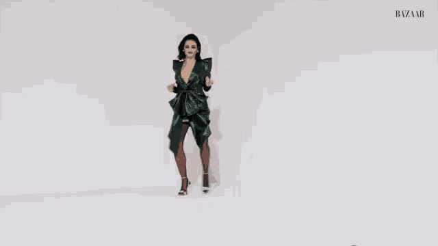 a woman in a green dress and tights is dancing .