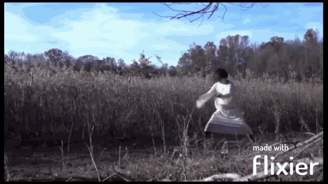 a woman in a white dress is standing in a field with the words made with flixier below her