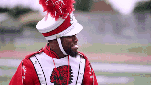 a man wearing a red and white uniform with a native american design on it