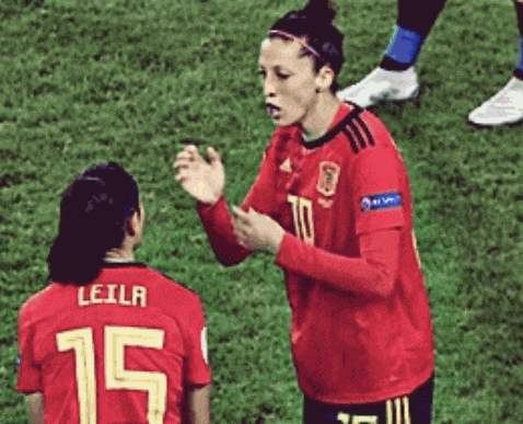 a female soccer player wearing a red jersey with the number 15 on it