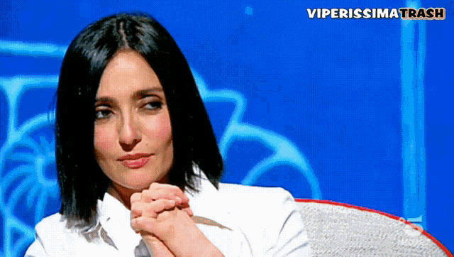 a woman sitting in front of a blue background with the words viperissima trash on the bottom