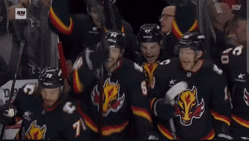a group of hockey players are huddled together with one wearing the number 80
