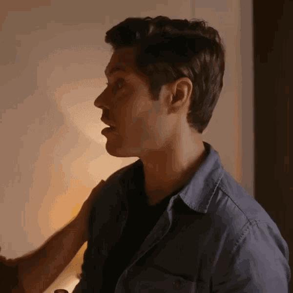 a man in a blue shirt has his mouth open and looks surprised