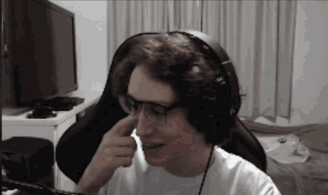a man wearing glasses and headphones is sitting in front of a tv