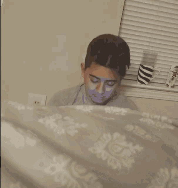 a man laying on a bed holding a spoon in his hand .