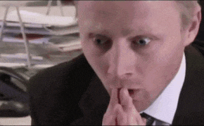 a man in a suit and tie is covering his mouth with his hand