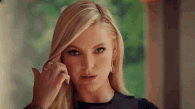 a close up of a woman 's face with a ring on her finger