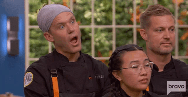 a man in a chef 's uniform looks surprised while two other people look on