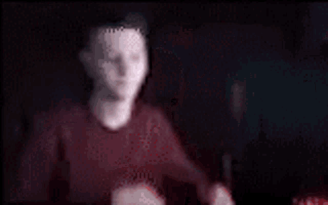 a blurry picture of a person in a dark room .