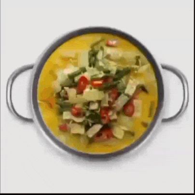 a pot of yellow soup with vegetables in it