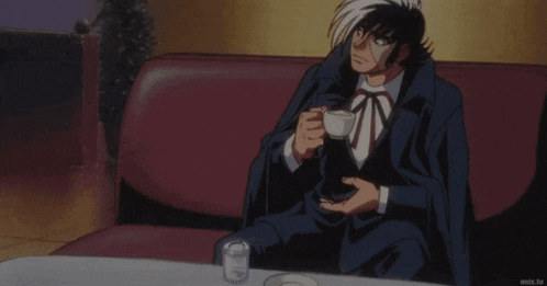 a man in a suit sits next to another man in a suit