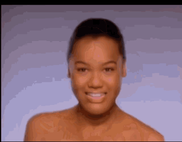 a woman without a shirt is smiling in a blurry photo