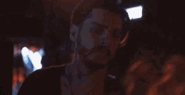 a man and a woman are kissing in a dark room .