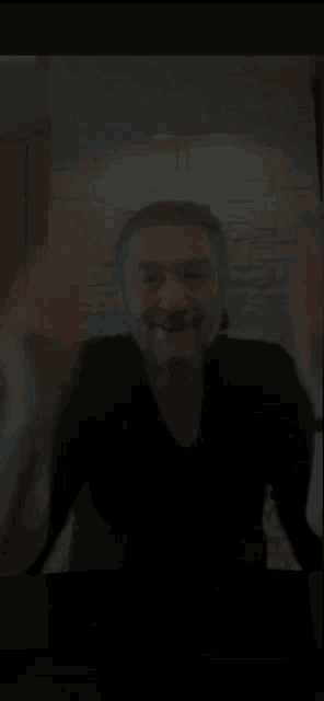 a man is making a heart shape with his hands in front of a mirror .