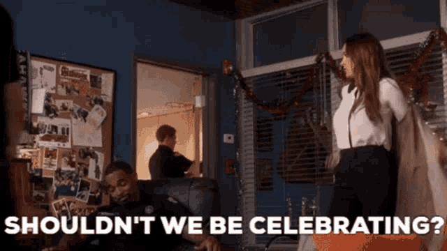 a woman standing next to a man sitting on a couch with the words shouldn 't we be celebrating