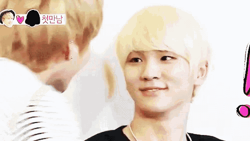a man with blonde hair is standing next to another man and looking at the camera .