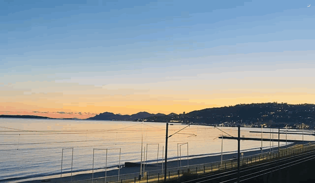 a sunset over a body of water with a few lines in the foreground
