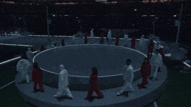 a group of people in white jumpsuits are dancing in a circle