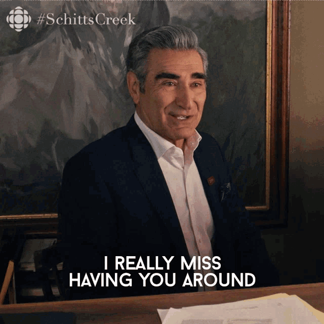 a man in a suit sits at a desk with the words i really miss having you around below him