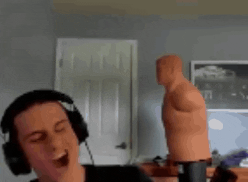 a man wearing headphones is singing into a microphone in front of a punching bag .