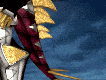 a close up of a dragon 's tail with a blue sky behind it