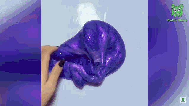 a person is playing with a purple slime that looks like a skull .