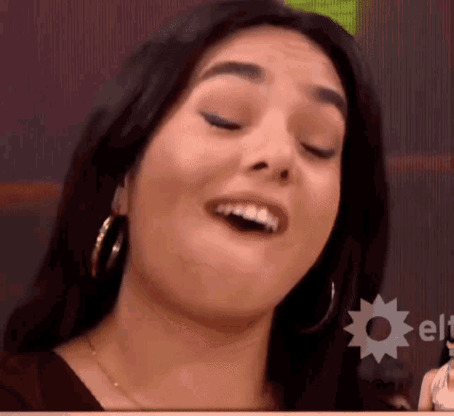 a close up of a woman making a face with her mouth open .