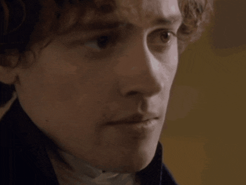a close up of a young man 's face with a serious look on his face .