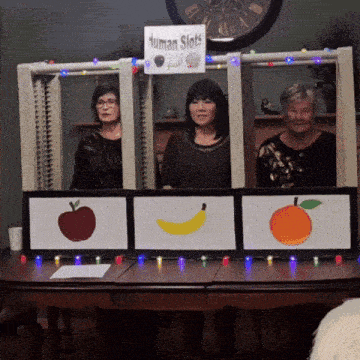 three women are standing in front of a table with a sign that says human slots