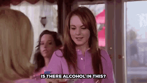a woman in a pink shirt is talking to another woman in a restaurant .