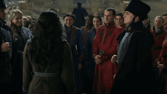 a man in a red coat is hugging another man in a blue coat