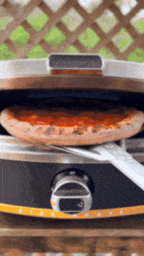 a pizza is being taken out of an oven with a fork