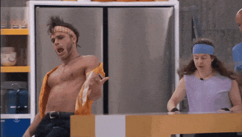 a man without a shirt is dancing in front of a fridge