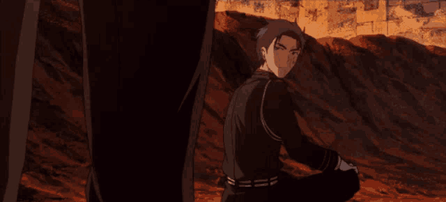 a man in a black shirt is kneeling down in front of a wall