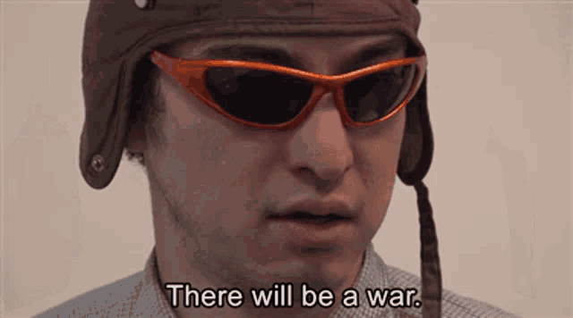 a man wearing a helmet and sunglasses says " there will be a war "