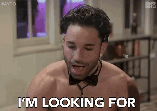 a shirtless man wearing a bow tie and choker is looking for a woman .