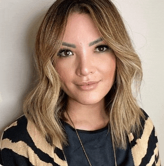 a woman wearing a zebra print sweater and a necklace is smiling for the camera .