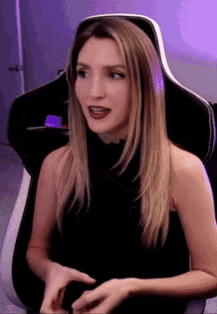 a woman in a black top is sitting in a white chair