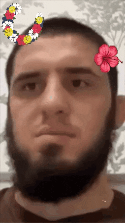 a man with a beard has flowers on his head