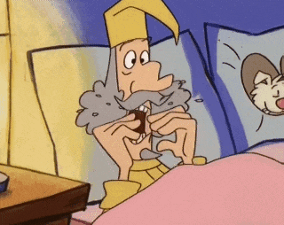 a cartoon of a man with a beard and a hat laying in bed