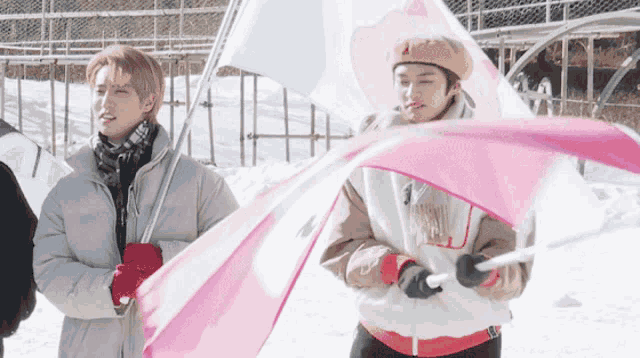 a man holding a pink flag in the snow