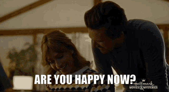 a man and a woman are looking at something with the words are you happy now
