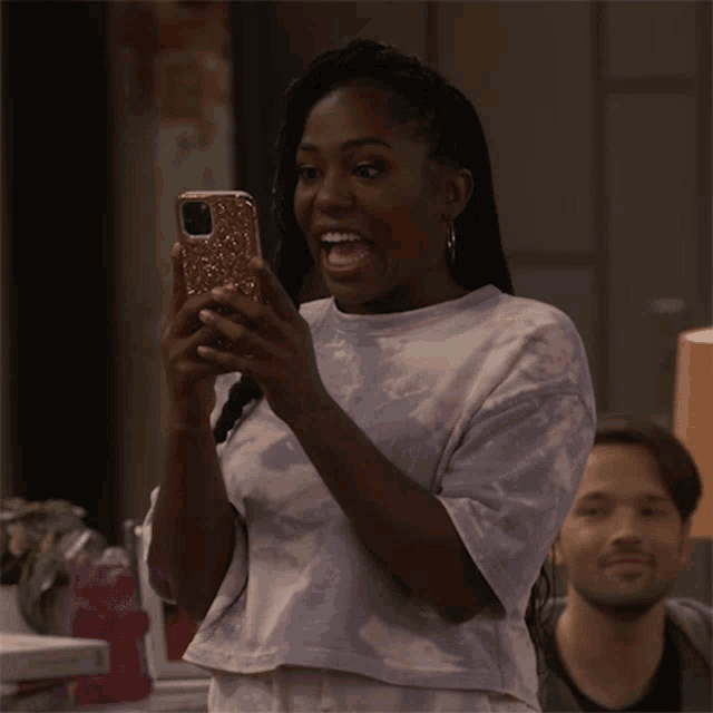 a woman in a tie dye shirt is taking a picture of herself with her phone