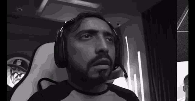 a man with a beard is wearing headphones and looking at the camera