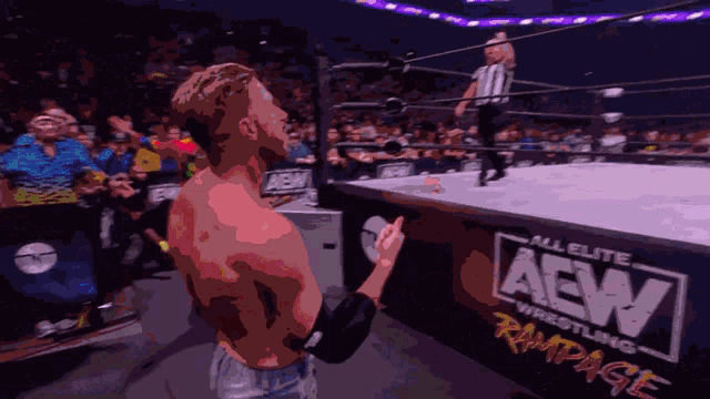a wrestler is standing in front of a sign that says aew wrestling