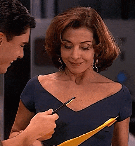 a woman in a blue dress is being interviewed by a man holding a pen