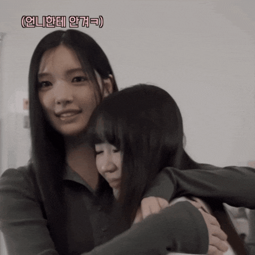 two asian girls hugging each other with a caption that says ' i 'm sorry '